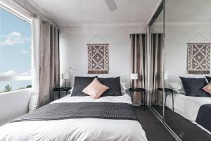 a bedroom with two beds and a large window at Bay Properties Pacific Sun in Yamba