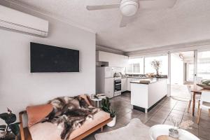 a living room with a couch and a kitchen at Bay Properties Pacific Sun in Yamba +12 photos