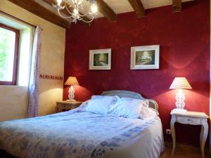 1 dormitorio con cama y pared roja en Gîte Le Brethon, 3 pièces, 4 personnes - FR-1-489-238, en Le Brethon