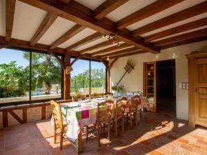 a dining room with a table and chairs and large windows at Maison de charme avec piscine privée, salle de sport proche de Bergerac et Périgueux - FR-1-616-132 in Villamblard