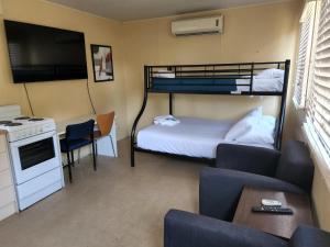 a small room with a bunk bed and a couch at Glenwood Tourist Park & Motel in Grafton