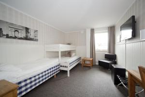 Habitación de hotel con 2 camas y TV en Lages Motel, en Borås