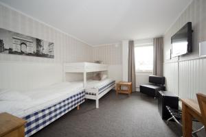 a hotel room with two beds and a television at Lages Motel in Borås