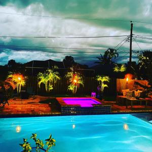 Una piscina de noche con luces violetas en Sanctuary Home Naples-Luxury Beach House with Private Pool and Oasis!, en Naples
