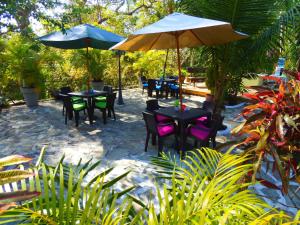 a patio with tables and chairs and umbrellas at Casa del Sol Bed and Breakfast in Contadora