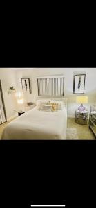um quarto com uma cama branca e duas mesas em Sanctuary Home Naples-Private Pool and Lanai! em Naples