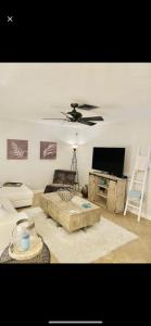 a living room with a couch and a ceiling fan at Sanctuary Home Naples-Private Pool and Lanai! in Naples