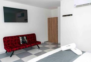 a living room with a red couch and a tv at Hotel El Olimpo in Santa Marta
