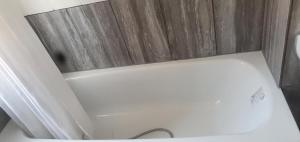 a white toilet in a bathroom with wooden walls at Tower Gardens Residence in London