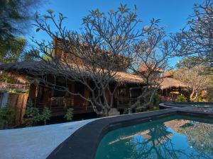 una casa con piscina di fronte a una casa di Sejuk Cottages a Gili Air