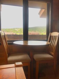 a table and two chairs in front of a window at K-Suite-Mt View-Resort-Pool-Hot Tub-Near RMNP & WP in Granby