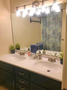 Un baño con dos lavabos y un espejo grande. en K-Suite-Mt View-Resort-Pool-Hot Tub-Near RMNP & WP, en Granby