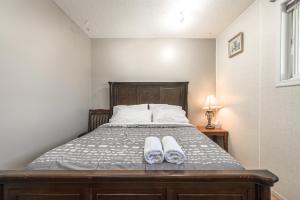 a bedroom with a bed with two slippers on it at H-Home by Deerfoot city in Calgary