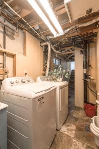 a laundry room with a washing machine and a sink at H-Home by Deerfoot city in Calgary