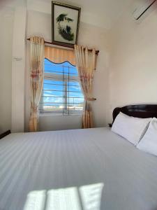 a bedroom with a large bed and a window at Hoa Bien Motel in Ly Son