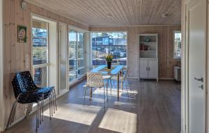 una cucina con tavolo, sedie e finestre di 4 Bedroom Amazing Home In Frvik a Færvik