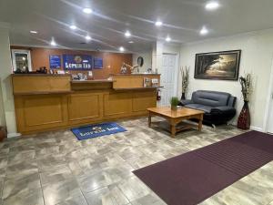 eine Lobby mit einem Wartezimmer mit einem Sofa und einem Tisch in der Unterkunft Lufkin Inn in Lufkin