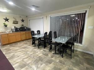 uma sala de jantar com mesas e cadeiras e uma cozinha em Lufkin Inn em Lufkin