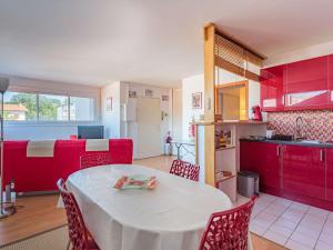 een keuken met een witte tafel en rode kasten bij Appartement Saint-Jean-de-Luz, 1 pièce, 4 personnes - FR-1-4-638 in Saint-Jean-de-Luz