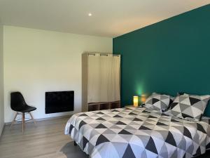 1 dormitorio con cama y pared verde en Gîte Isle-et-Bardais, 3 pièces, 5 personnes - FR-1-489-389, en Isle-et-Bardais