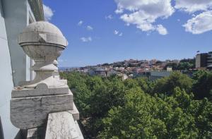 a stone statue with a view of a city at Hotel Dom Sancho I in Lisbon