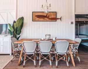 a dining room with a wooden table and chairs at Bay Properties Beach House Upstairs in Yamba