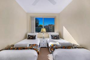 - 2 lits dans une chambre avec fenêtre dans l'établissement Park Beach Retreat, à Coffs Harbour
