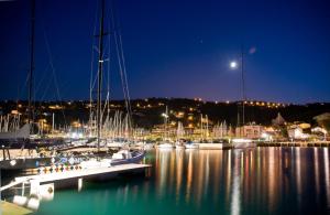 a group of boats docked in a marina at night at Hotel San Rocco in Muggia