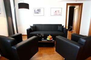 a living room with a black couch and a table at Hotel San Rocco in Muggia