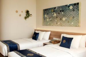 um quarto de hotel com duas camas e um quadro na parede em Antero Hotel Jababeka em Cikarang