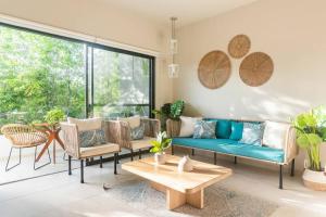 a living room with a blue couch and chairs at Aqua in Playa del Carmen