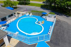 an overhead view of a large swimming pool with chairs and umbrellas at American Inn in Carlisle