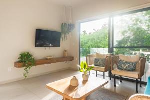 a living room with a tv and a couch and a table at Aqua in Playa del Carmen