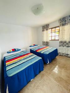2 camas en una habitación con sábanas azules en CASA DEL SOL, en Ica