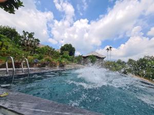 a pool with a fountain in the water at ByVe Garden in Na Nội