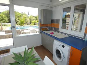 uma cozinha com uma máquina de lavar roupa e um lavatório em Proprizen em Rivière-Salée
