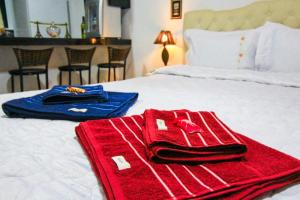 a red towel is sitting on a bed at Aconchego Véu da Noiva in Campos do Jordão