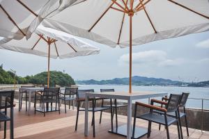 a row of tables and chairs with umbrellas at Glamprook Shimanami in Imabari