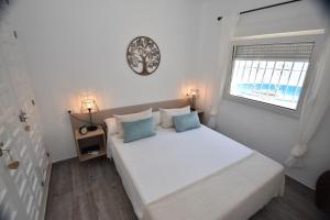 een witte slaapkamer met een groot bed en een raam bij Julitte 91 by homeprive in Denia +11 foto's