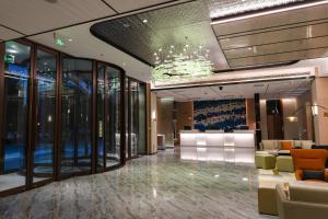 a lobby with chairs and a chandelier in a building at Holiday Inn Express Tianjin Binhai by IHG in Binhai