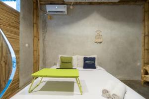 a bedroom with a bed with a green table at Urbanview Ta-ke Residence Blok M by RedDoorz in Jakarta
