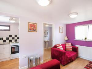 a living room with a red couch and purple walls at Bainside Holiday Lodge in Kirkby on Bain