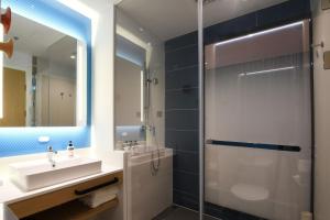 a bathroom with a sink and a shower at Holiday Inn Express Tianjin Binhai, an IHG Hotel in Binhai