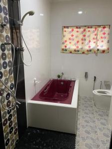 y baño con lavabo rojo y bañera. en Kak Pah Homestay, en Kajang
