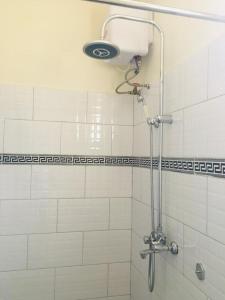 a shower with a shower head in a bathroom at The Greenville Home in Mbarara