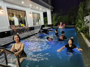 a group of people in a swimming pool in a house at Lotus Hotel Ninh Bình in Ninh Binh