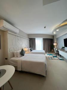 AEON SUITES STAYCATION managed by ARIA HOTEL tesisinde bir odada yatak veya yataklar