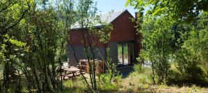 a small red brick house in the middle of trees at M2 in Złoty Stok