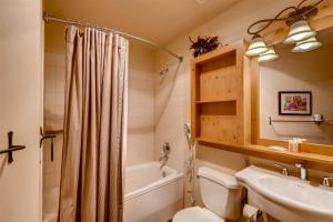 a bathroom with a toilet and a tub and a sink at 2 Bedroom Colorado Vacation Rental In River Run Village With Pool And Hot Tub Access in Keystone +13 photos