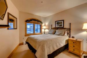 a bedroom with a large bed and two windows at 2 Bedroom Colorado Vacation Rental In River Run Village With Pool And Hot Tub Access in Keystone